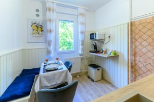 a small room with a table and a kitchen at Kaposvár Deluxe Apartman in Kaposvár
