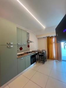 a kitchen with green cabinets and a table at Caraceni Apartaments 2 in Castel di Sangro
