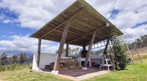 a gazebo with a grill in a field at Lodge La Ilusión in Ibarra