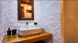 a bathroom with a stone sink and a mirror at Lodge La Ilusión in Ibarra