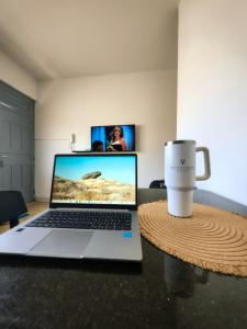 a laptop computer sitting on a table with a coffee cup at Ap Umarizal l WiFi 500MB in Belém