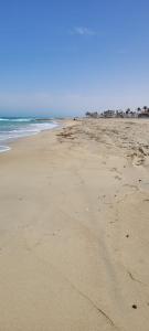 an empty beach with footprints in the sand at Dar Sidi Mohamed in Zarzis