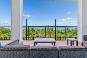 a patio with a table and chairs and a view of the ocean at 2 Ocean View Villas with Private Pool in Luquillo +75 photos