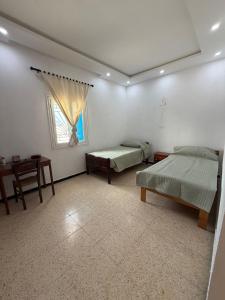 a room with two beds and a window at Dar Sidi Mohamed in Zarzis