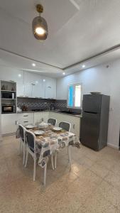 a kitchen with a table with chairs and a refrigerator at Dar Sidi Mohamed in Zarzis