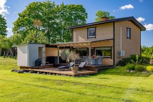 a tiny house with a deck and a patio at Ala Sarise saunamaja in Sarise