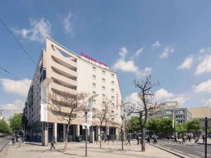 a large white building on a city street at Hôtel Mercure Lyon Centre Charpennes Parc de la Tête d'Or in Villeurbanne
