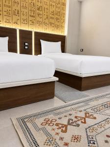 two beds in a room with a rug at Pyra King Royal Pyramids Hotel in Cairo