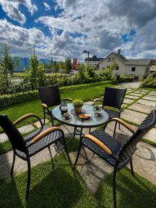 a patio with a table and chairs on the grass at My Sweet Home in Fauske