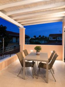 a table and chairs on a patio with a view at Olea Verde Loft Apartment in Lefkimmi