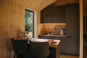 a kitchen with a counter and chairs in a cabin at Ruoliškis tiny house in Biržai