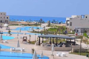 a resort with several pools and tables and umbrellas at Remas resort in El Alamein