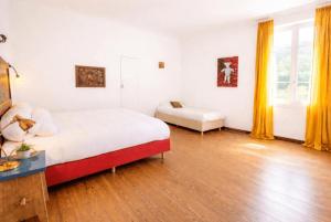 a bedroom with a bed and a table and yellow curtains at villa marguerite in Lunas