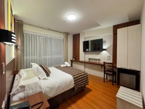 a hotel room with a bed and a desk and a television at Hotel Yanahuara Suite in Arequipa +6 photos