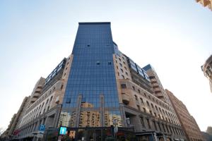 a tall building with glass windows on a street at Appartament Buzanda 17 in Yerevan
