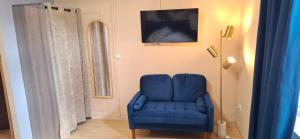 a blue chair in a room with a window at Le Square Inn in Turckheim
