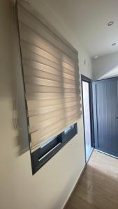 a room with a window with wooden blinds on a wall at Se Soul in Asprovalta