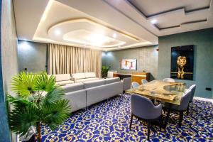 a living room with a couch and a table at Swisse International Rancho Valeria Hotel & Suites in Warri