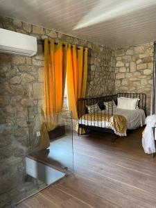 a bedroom with a bed and a stone wall at Casa do Torreão in Trancoso +3 photos