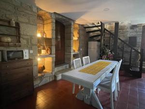 a kitchen and dining room with a table and chairs at Casa do Torreão in Trancoso