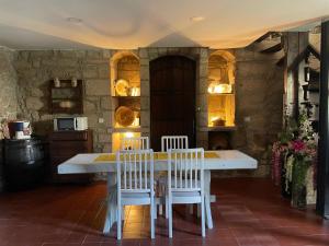 a kitchen with a white table and chairs at Casa do Torreão in Trancoso