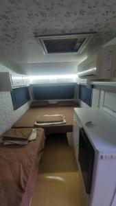 a small room with a desk and a bed in it at Aquariumi Jale Camping in Jal