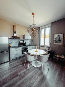 a kitchen with a table and chairs in a room at La Source de la Scance in Verdun-sur-Meuse +7 photos