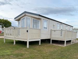 a mobile home with two decks on the grass at Caravan 607 in Clacton-on-Sea
