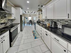 a kitchen with white cabinets and a tile floor at Ferrymans Landing in Aransas Pass
