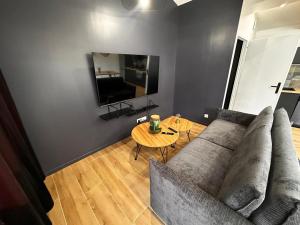 a living room with a couch and a table at BlakRiverHouse - Sèvre Niortaise in Niort