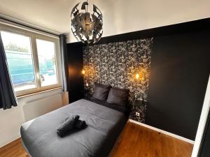 a bedroom with a bed with a black wall at BlakRiverHouse - Sèvre Niortaise in Niort