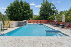 a large swimming pool with lounge chairs at 2 Ocean View Villas with Private Pool in Luquillo