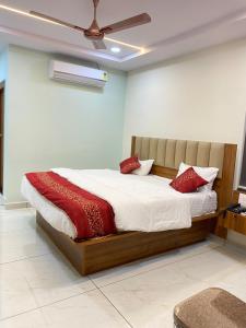 a bedroom with a large bed with red pillows at Hotel PR Royal in Bhīmavaram +27 photos