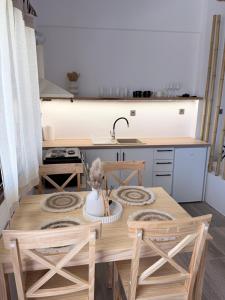a kitchen with a wooden table with chairs and a sink at Kanal Vstay #1 in Kithnos