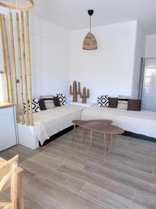 a living room with two beds and a table at Kanal Vstay #1 in Kithnos