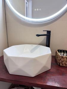 a bathroom with a white sink and a mirror at Kanal Vstay #1 in Kithnos