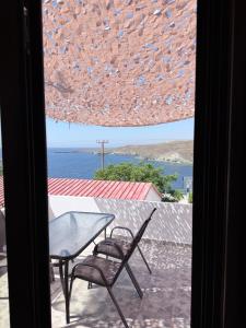 a table and chairs on a balcony with a view of the ocean at Kanal Vstay #1 in Kithnos