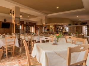 a restaurant with tables and chairs with white table cloth at Albergo De Jean in Garzeno