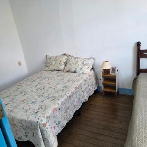 a bedroom with a bed and a table with a lamp at Casa Centro Exclusiva Diamantina in Diamantina