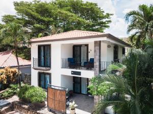 a house with a balcony and palm trees at Coco Garden Suites in Coco