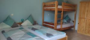 a bedroom with two bunk beds and a door at Ferienwohnung am Waldrand in Herdwangen-Schönach +19 photos