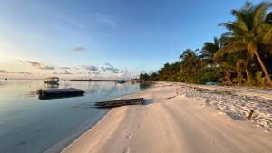 a beach with two boats in the water at EcoWave Retreat- Muli in Muli +16 photos