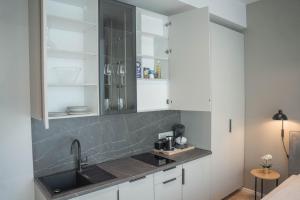 a kitchen with white cabinets and a sink at Luise LuXe Suites in Tallinn +99 photos