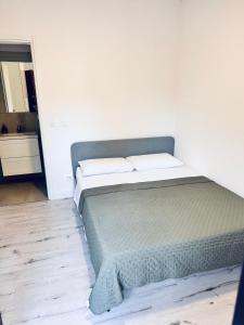 a bed in a room with a white wall at Aden b&b in Casa Calari