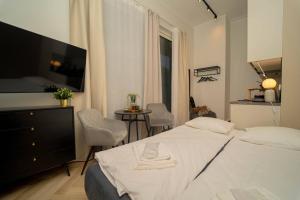 a bedroom with a bed and a tv and a table at Luise LuXe Suites in Tallinn