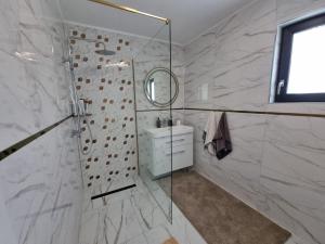 a bathroom with a shower and a sink at La Casute Piatra Teiului in Poiana Largului +12 photos