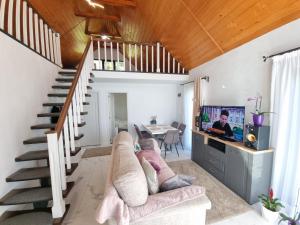 a living room with a staircase and a couch at La Casute Piatra Teiului in Poiana Largului