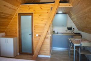 a small kitchen with a staircase in a wooden house at La Casute Piatra Teiului in Poiana Largului