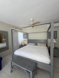 a bedroom with a canopy bed with a bench at Cadaques Caribe Bayahibe Palmera in Bayahibe