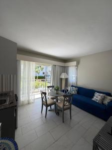 a living room with a blue couch and a table at Cadaques Caribe Bayahibe Palmera in Bayahibe